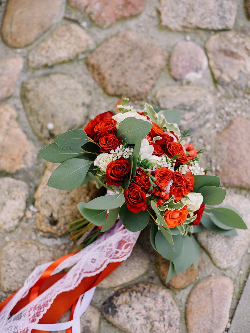 Bridal and prom bouquet with red mini roses, eucalyptus, freesia and lisianthus.