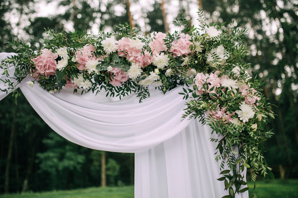 Wedding arch with flowers and fabrics.