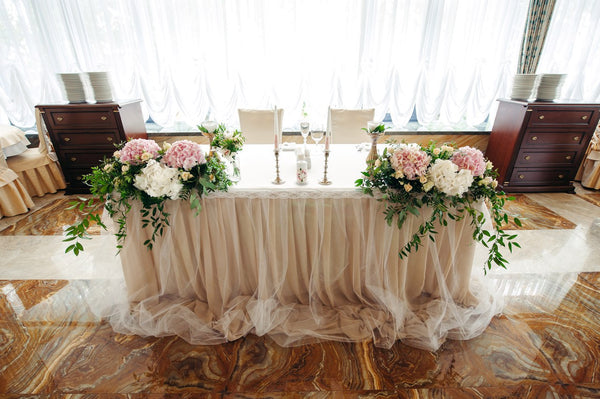 One of the most popular trends in wedding at the moment is having a sweetheart table.Some couples are choosing to have ornate, luxurious sweetheart tables with lush floral garlands that spill onto the floor, candles and sequined table linens, while others are choosing to have plush, vintage chairs seated around a rustic wooden table with a scatter of lanterns for a more simple, yet still elegant. Includes: Flower arrangements: white and pink hydrangea, white lisianthus, creamy mini roses,assorted greens. Ca
