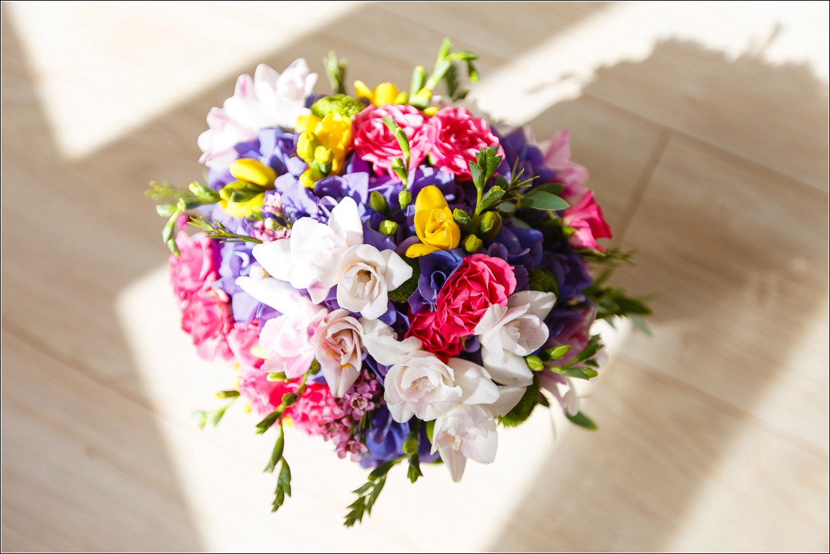 Bridal and prom bouquet in rainbow color with freesia, hydrangea and lisianthus.
