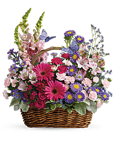 Take a walk through a country meadow with this fresh flower basket!  Includes:  Pink gerberas and mini roses, purple astras, light pink alstroemerias, carnations and snap dragons. Basket Free message card