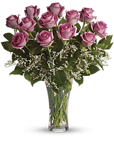 One dozen pink roses are gathered with white limonium and rich green salal in a classic trumpet vase she'll use again and again. Includes: Pink roses, white limonium, green salal. Vase Free message card