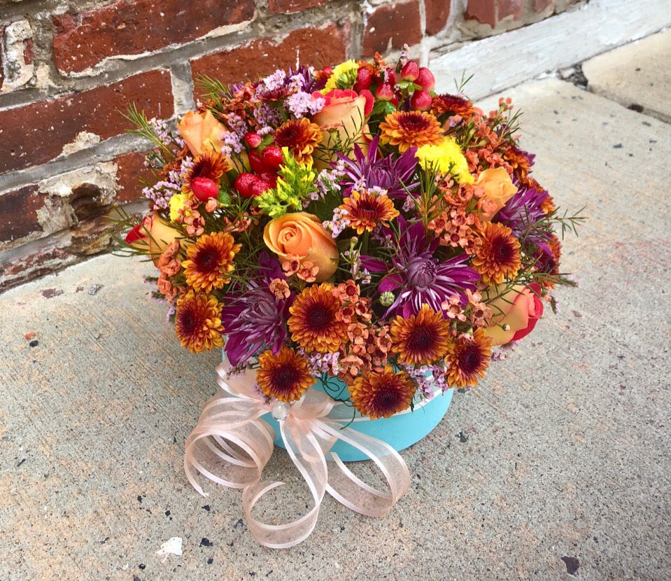 Capture the natural beauty of autumn with this stunning arrangement in an elegant box, sure to brighten any fall day.  Includes:  Purple chrysanthemums, brown daisies, red alstroemerias, orange wax flowers, solidago, peach roses.  Velvet box Free message card