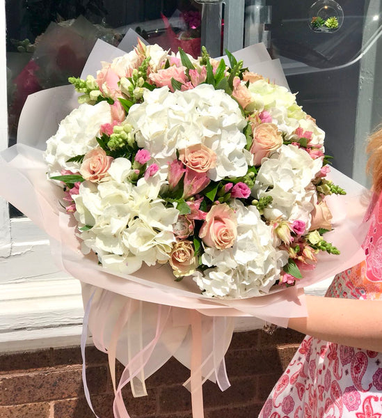 Stunning in its simplicity, this innocent harmony of light pink roses and snow white hydrangeas are a heartfelt way to send your very best.  Includes:  White hydrangea, light pink roses, pink alstoemerias, assorted greens. Wrapping in a craft paper. Free message card