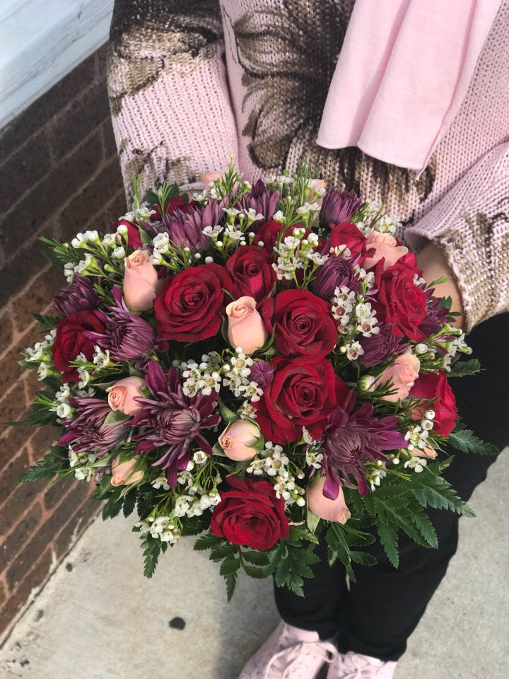 This wildly romantic box is called "Crazy for You" because that's what she'll be when she sees it.   Includes:  Red and pink mini roses, purple daisies, white wax flowers,fern. Floral box Free message card