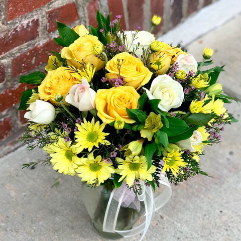 Would you walk a mile for one of her smiles? You can bet she'll be walking toward you, arms outstretched, when she receives this gorgeous array. And wait till you see the smile she gives you.  Includes:  Yellow and white roses, yellow alstroemeria, yellow daisies, wax flowers, fern. Vase Free message card