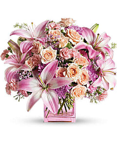 Peach, pink and lavender blooms are a sweet and innocent way to show your affection.  Includes:  Pink lilies, creamy mini roses, lavender daises, assorted greens. Vase Free message card