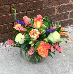 Greet a loved one with the golden glow of autumn. Like a trip to the Tuscan countryside, this garden of fall flowers warms the heart with its orange and gold blooms.  Includes:  Orange and white roses, yellow alstroemerias, peach statice, blue veronica. Artificial pumpkin. Free message card